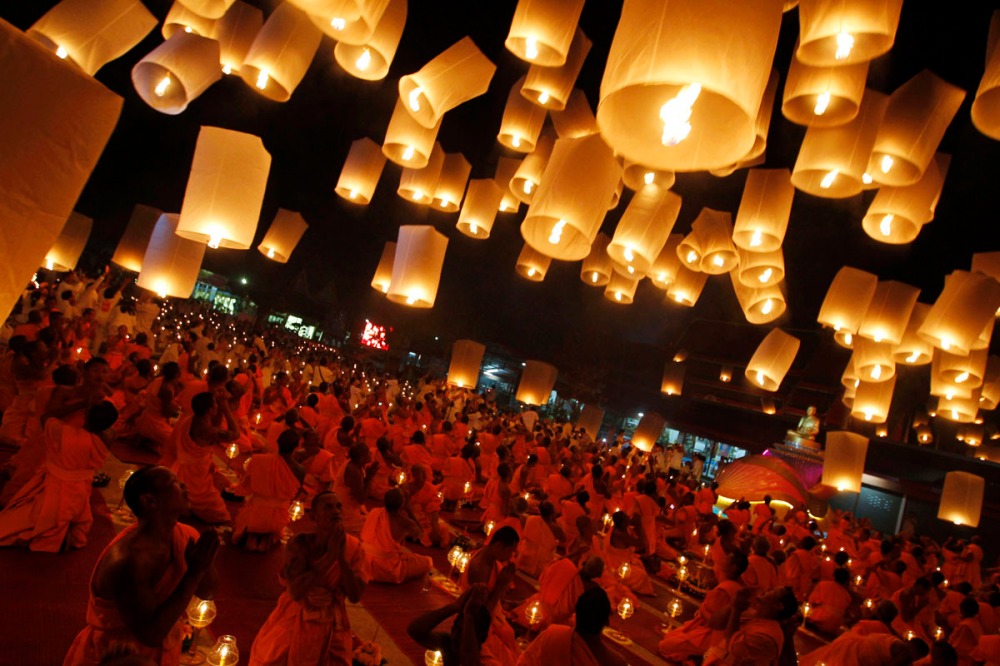 Buddhist monks release paper lanterns into the sky in Suphan Buri province